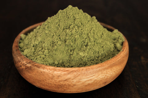 Green Jongkong plant leaf powder shown in wooden bowl