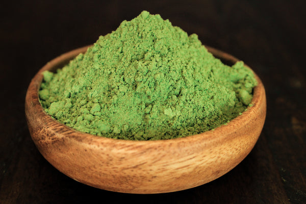 Fresh raw moringa powder in highest quality shown in a wooden bowl